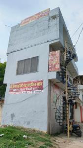 a white building with a fire hydrant in front of it at माँ विंध्यवासिनी होम स्टे कसया कुशीनगर in Kasia
