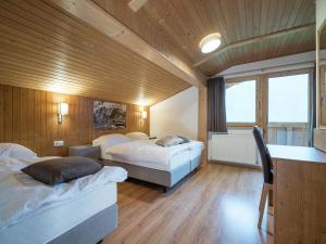 a bedroom with two beds and a chair in it at Chalet in Wald near Zillertal Arena in Königsleiten