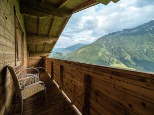 a porch with a chair and a view of mountains at Chalet in Wald near Zillertal Arena in Königsleiten