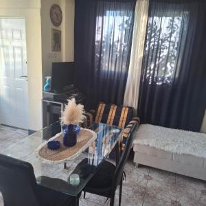 a living room with a glass table and a couch at Dusica in Vrnjačka Banja