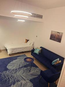 a living room with a blue couch and a bed at Boutique Studio , Guest Suit , AJMAN in Ajman  +26 photos