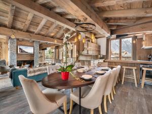 a dining room with a wooden table and chairs at Appartement Duplex avec Terrasse, Jacuzzi et Cheminée - Val-d'Isère - FR-1-567-63 in Val dʼIsère