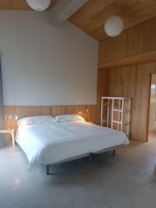a bedroom with a large white bed with a wooden ceiling at Barrio del Norte in Villademoros