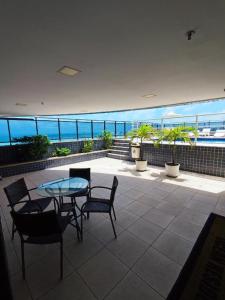 a patio with a table and chairs and a view of the ocean at Flat Vista Mar - Fortaleza in Fortaleza