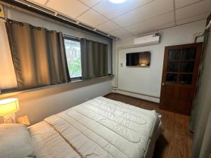 a small bedroom with a bed and a window at Mango Hostel - 420 Friendly in Bangkok +12 photos