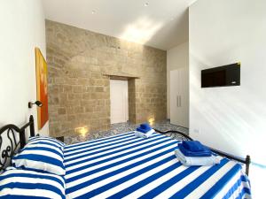 圣乔治阿克雷马诺Domus Giada的一间卧室配有一张带蓝色和白色条纹床单的床