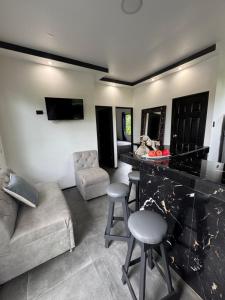a living room with a couch and a bar with stools at Selva y Confort #3 AC in Cahuita