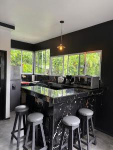 a kitchen with a counter with stools and a microwave at Selva y Confort #3 AC in Cahuita