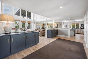 a large kitchen and living room with blue cabinets at Southern Dunes home by Peace Vacations in Georgetown