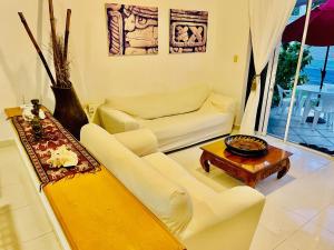 a living room with two white couches and a table at Superior Basic Room With Swimming Pool Air Conditioning and Parking in Playa del Carmen