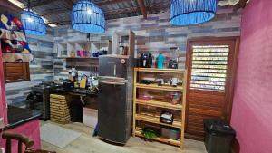 a kitchen with a refrigerator and a desk and blue lights at Casa Josuá in Nísia Floresta +8 photos
