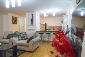 a living room with a couch and a kitchen at Fabulous 3-bedroom duplex apartment in Nairobi