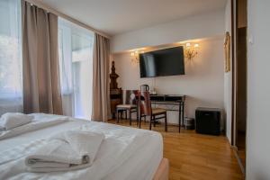 a hotel room with a bed and a desk and a television at Hotel Attaché in Vienna +89 photos