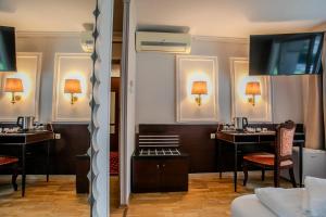 a hotel room with two desks and a flat screen tv at Hotel Attaché l contactless check-in in Vienna