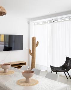 comedor con mesa y cactus en Gran apartamento Sorolla, en Playa de Miramar
