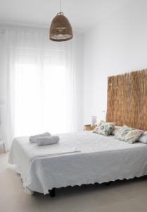 Un dormitorio con una cama grande con sábanas blancas. en Gran apartamento Sorolla, en Playa de Miramar