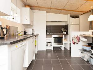 a kitchen with white cabinets and a tile floor at 4 star holiday home in Dronningmølle in Dronningmølle