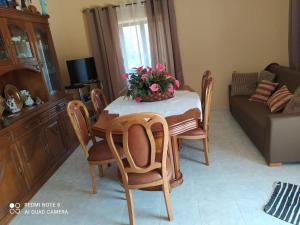 a dining room table and chairs with flowers on it at Casa Meitriz in Castro Daire