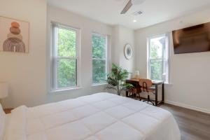 a white bedroom with a bed and a desk and windows at Penthouse Condo with Rooftop Deck in Philadelphia! in Philadelphia