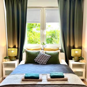 a bedroom with a large bed with two windows at Garone in Gdańsk