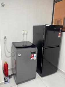 Un pequeño refrigerador al lado de un extintor rojo en NEW Batu Kawan 2 Bedrooms Suite near IKEA-Columbia Asia Hospital-BKIP-UOW Kdu, en Simpang Ampat 11 fotos más