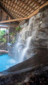 a waterfall next to a pool of water at Pousada Carumbé Lavras Novas in Lavras Novas