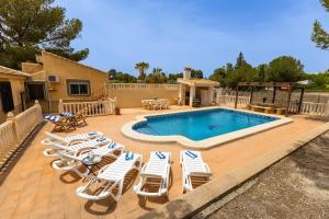 a group of chairs and a swimming pool with a deck at Villa Aurea in La Alcayna