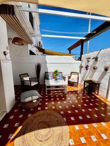 Una sala de estar con un sofá y sillas y una mesa. en Barrosa Living, en Chiclana de la Frontera