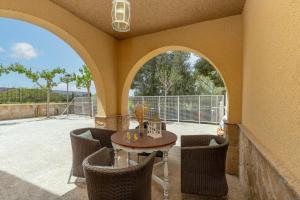 a patio with a table and chairs and a window at Villa Aurea in La Alcayna