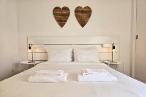 two towels on a bed with two hearts on the wall at Beach House on Faro Island with a Dreamy Terrace and 7 Beds for the Perfect Escape in Faro