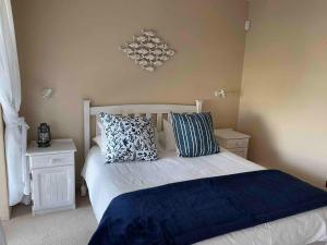 a bedroom with a bed with two pillows on it at Under Milkwood in Witsand