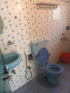 a bathroom with a blue toilet and a sink at Caitan Villa Candolim in Candolim