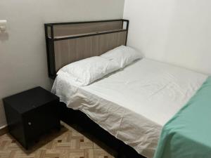 una piccola camera da letto con un letto e un comodino di Aparta suite Torre de Prado 402 a Medellín