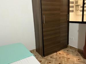 una camera con una porta, un letto e un armadio di Aparta suite Torre de Prado 402 a Medellín Altre 2 foto