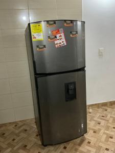 un frigorifero in acciaio inossidabile con molte calamite sopra. di Aparta suite Torre de Prado 402 a Medellín