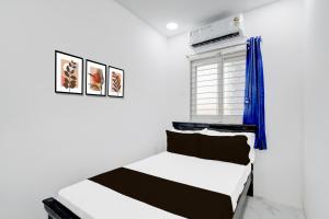 a bedroom with two beds and a window at Hotel O R J Residency in Pedda Ambarpet