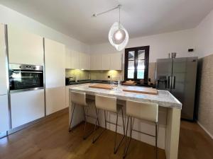a kitchen with a large island with bar stools at Villa Tattoo in Donoratico