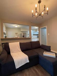 a living room with a couch and a chandelier at Modern Comfort Near Colleges Perfect Mid Term Stay in Wilkes-Barre