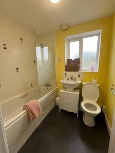 a bathroom with a toilet and a sink and a bath tub at Trowbridge House Long Stays Free Parking and Wifi in Swindon +15 photos
