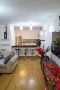 a living room with a couch and some bar stools at Fabulous 3-bedroom duplex apartment in Nairobi +28 photos