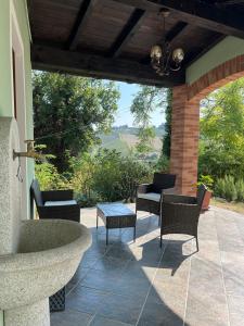 a patio with a stone fountain and chairs and a table at I Pesci de Boschi in Borgo Priolo