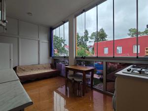 a kitchen with a table and some large windows at Guesthouse Mery in Kobuleti