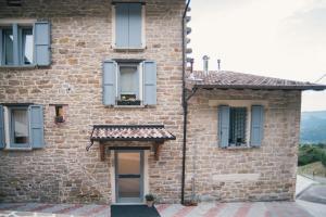 a brick building with a door and a window at Locanda Vecchio Caseificio in Toano