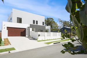 a white house with a red brick garage at Marakari Mount Coolum Getaway in Marcoola