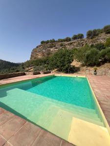 a large swimming pool with a mountain in the background at Hotel Rural Hacienda de Ronda in Ronda