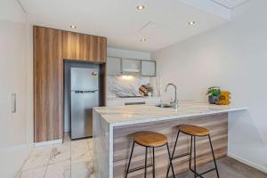 a kitchen with a counter and two stools at a kitchen island at Glebe Park Cityside with Style in Canberra