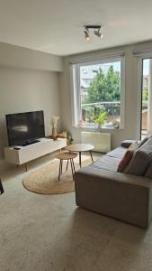 un salon avec un canapé et une télévision dans l'établissement Felix De Haan, au Coq