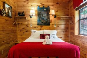 two teddy bears sitting on a bed in a cabin at Comforts Me Hot Tub in Sevierville