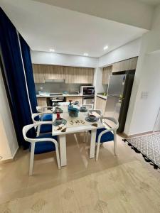 a kitchen with a white table and two chairs at 4 Bedrooms Penthouse Villa, Marassi in El Alamein