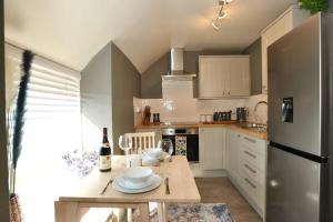 a kitchen with a table with wine glasses on it at Sandpiper Apartment in Benllech +5 photos